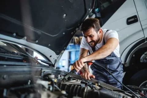 Mechanik naprawia silnik pod maską samochodu
